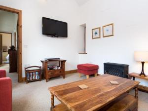 a living room with a wooden table and a flat screen tv at 1 Bed in Borrowdale SZ163 in Keswick