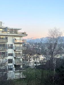 duży budynek apartamentowy z drzewami przed nim w obiekcie Studio Cosy 15' Genève w mieście Annemasse