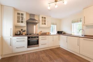 a kitchen with white cabinets and a stove at 2 Bed in Eskdale SZ346 in Santon Bridge