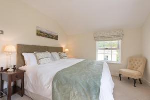 a bedroom with a large white bed and a chair at 2 Bed in Eskdale SZ346 in Santon Bridge
