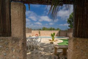 un patio con tavolo, sedie e piscina di Rustic studio with private pool and private garden a Biniali