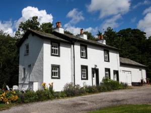 a large white house with black windows and flowers at 2 Bed in Eskdale SZ346 in Santon Bridge