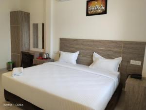 a bedroom with a large bed with white sheets and pillows at RedFox Hotel-T.Nagar in Chennai