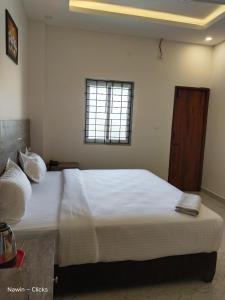 a bedroom with a large white bed with a window at RedFox Hotel-T.Nagar in Chennai