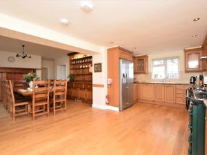 a kitchen and dining room with a table and a refrigerator at 7 Bed in Exmoor 83059 in Parracombe