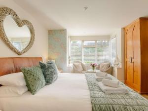 a bedroom with a large bed with a heart mirror on the wall at 1 Bed in Hythe 89966 in Hythe