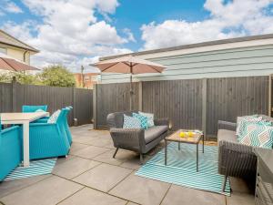 a patio with chairs and a table and an umbrella at 1 Bed in Hythe 89966 in Hythe