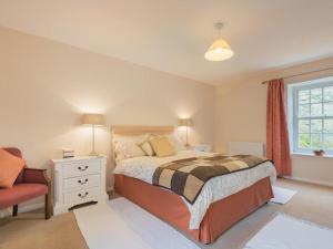 um quarto com uma cama, uma cadeira e uma janela em 4 Bed in Patterdale SZ170 em Patterdale