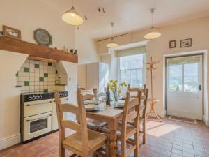 a dining room with a table and chairs and a kitchen at 4 Bed in Patterdale SZ170 in Patterdale