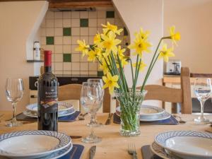a table with a bottle of wine and yellow flowers at 4 Bed in Patterdale SZ170 in Patterdale