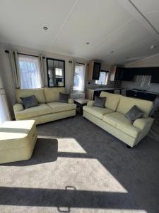 a living room with two couches and a kitchen at Royal Oak Caravan Park in Skegness