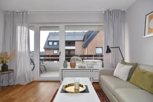 uma sala de estar com um sofá e uma grande janela em Alice, Whg 9, 1 OG em Westerland