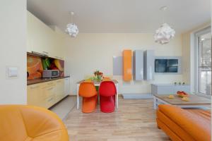 a kitchen with orange chairs and a table in a room at Lilly Aquamarina SeaView by Rent like home in Międzyzdroje +14 photos