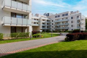 an apartment building with a walkway in a park at Lilly Aquamarina SeaView by Rent like home in Międzyzdroje