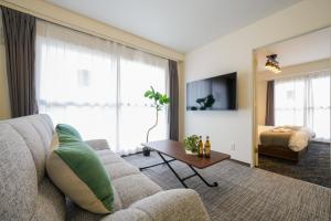 a living room with a couch and a bed at 37th Matsui Building 1002 - Vacation STAY 14736 in Sapporo