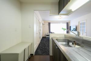 a white kitchen with a sink and a window at 37th Matsui Building 1002 - Vacation STAY 14736 in Sapporo
