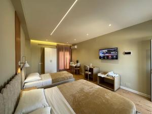 a hotel room with two beds and a television at Arial Lofts in Vlorë