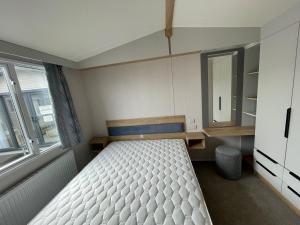 a small bedroom with a bed and a mirror at Royal Oak Caravan Park in Skegness