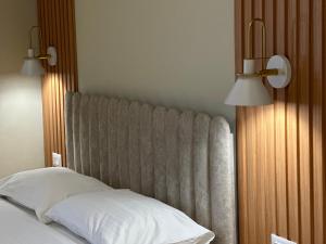 a bedroom with a bed with two lights above it at Arial Lofts in Vlorë