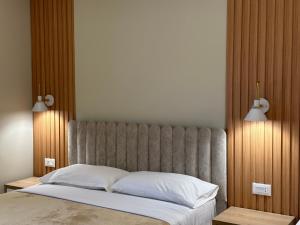 a bedroom with a large bed with two lamps on it at Arial Lofts in Vlorë