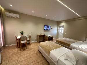 a hotel room with two beds and a table and a television at Arial Lofts in Vlorë