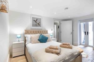 a bedroom with a large bed with two pillows on it at Wanstead, Escape London in London-Luxury 2 Bed in London
