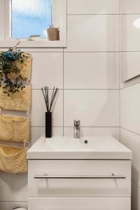 a white bathroom with a sink and a window at Dinbnb Apartments I Best of Both Worlds I 80sqm with 2 baths and Bathtub in Bergen