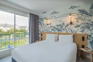 a bedroom with a large bed and a window at L'Escale Marine, The Originals Relais in Crozon