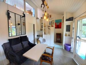 una sala de estar con un sofá y una mesa en Saint Palais sur Mer - VILLA MITOYENNE - HAUTS de ST PALAIS - PISCINE, en Saint-Palais-sur-Mer