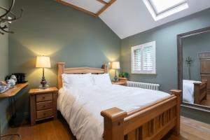 Stable Lodge - Boutique Bed & Breakfast في تشلتنهام: غرفة نوم بسرير كبير ونافذة
