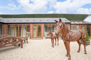 a statue of a horse and a baby horse in front of a house at Stable Lodge - Boutique Bed & Breakfast in Cheltenham