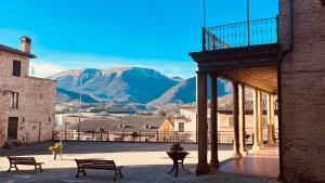 a building with benches and a mountain in the background at La Sibillina in Sarnano