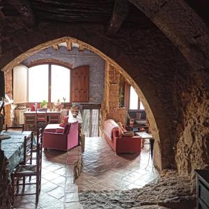 a living room with an archway in a stone building at Ca l'Aleixa Rooms in Bisbal de Falset