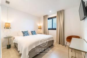 Un dormitorio blanco con una cama y una ventana. en HigueronRentals Twin apartments, en Málaga