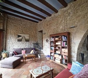 a living room with a couch and a book shelf at Ca l'Aleixa Rooms in Bisbal de Falset