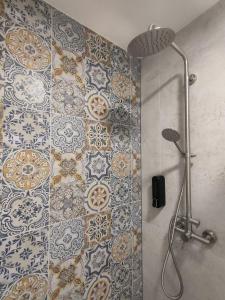 a bathroom with a shower with a tile wall at Slate Apartament Polanica - Zdrój in Polanica-Zdrój