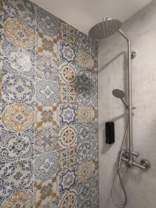 bagno con doccia e parete piastrellata di Slate Apartament Polanica - Zdrój a Polanica-Zdrój