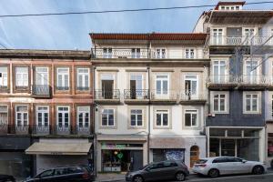 een groep gebouwen met auto's voor hen geparkeerd bij São Bento Bright Studio in Porto