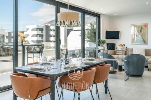 Un comedor con una mesa con copas de vino encima. en HigueronRentals Twin apartments, en Málaga