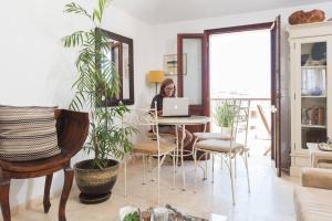 a woman sitting at a table with a laptop at Charming New Apt in Jaffa Near Sea in Tel Aviv