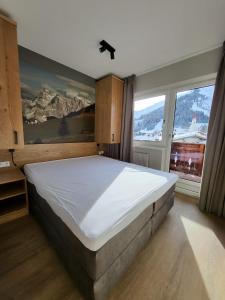 a bedroom with a large bed and a large window at Almtraum Berwang in Berwang