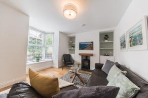 a living room with a couch and a chair at Stylish, family friendly central Windermere home with wood burner in Windermere