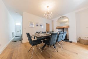 a dining room with a table and chairs at Stylish, family friendly central Windermere home with wood burner in Windermere