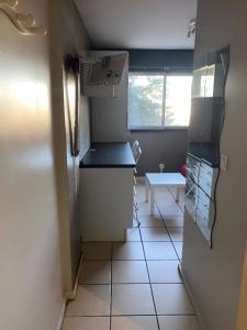a small kitchen with a refrigerator and a table at Studio Cozy 245 in La Mulatière