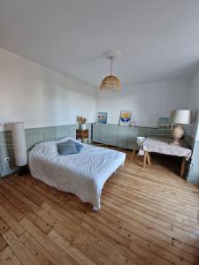 a bedroom with a bed and a desk in it at Magnifique maison au cœur d'un jardin paysager in Breuillet