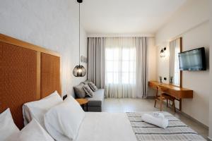 a hotel room with a bed and a desk at Pedi Beach Hotel in Symi
