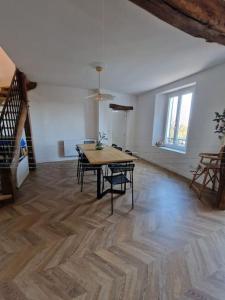 a room with a table and chairs and a staircase at Magnifique maison au cœur d'un jardin paysager in Breuillet