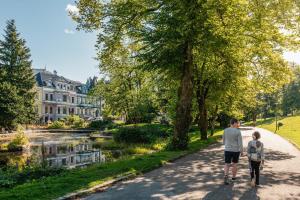 a man and a boy walking down a path next to a river at Dinbnb Apartments I Best of Both Worlds I 80sqm with 2 baths and Bathtub in Bergen