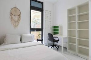 een slaapkamer met een bed, een bureau en een stoel bij Garden Oasis by Five Stay in Tel Aviv