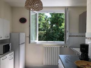une cuisine avec une fenêtre et un comptoir de cuisine dans l'établissement Appartement en rez-de-chaussée, à Valence